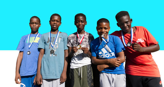Five boys wearing medals